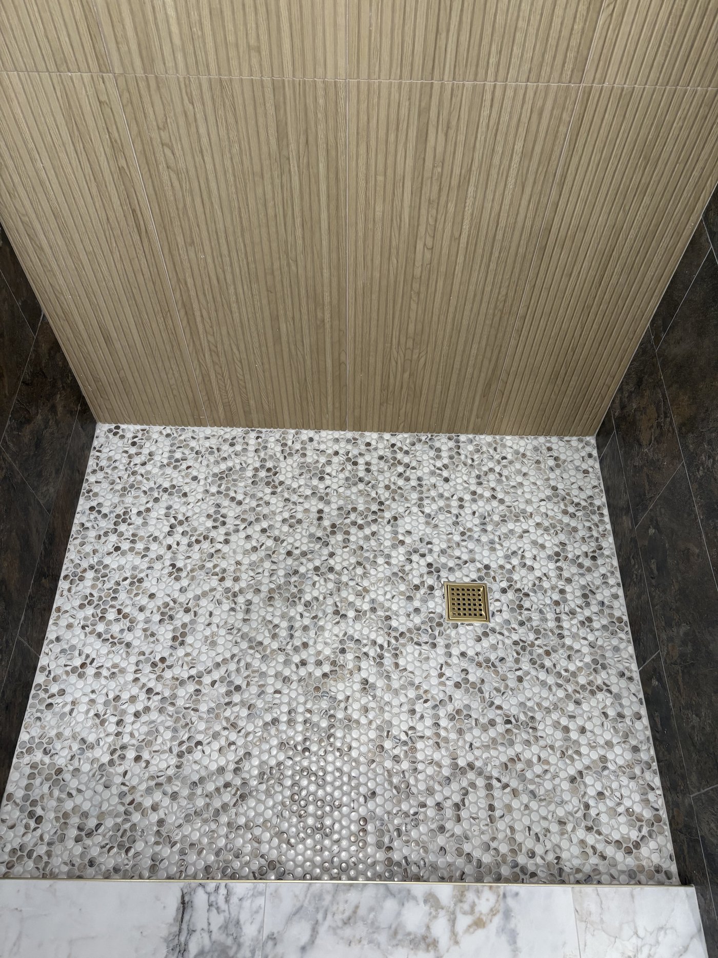 Walk-in shower with hexagon penny mosaic and reeded wood feature wall