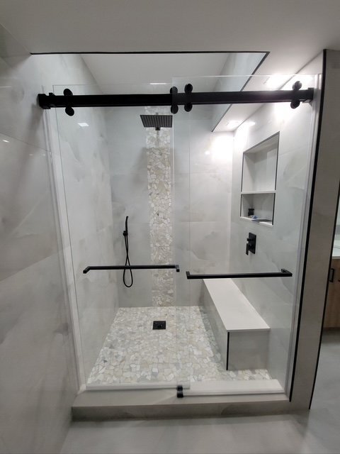 Penny-tile shower floor with built-in bench and sliding glass door