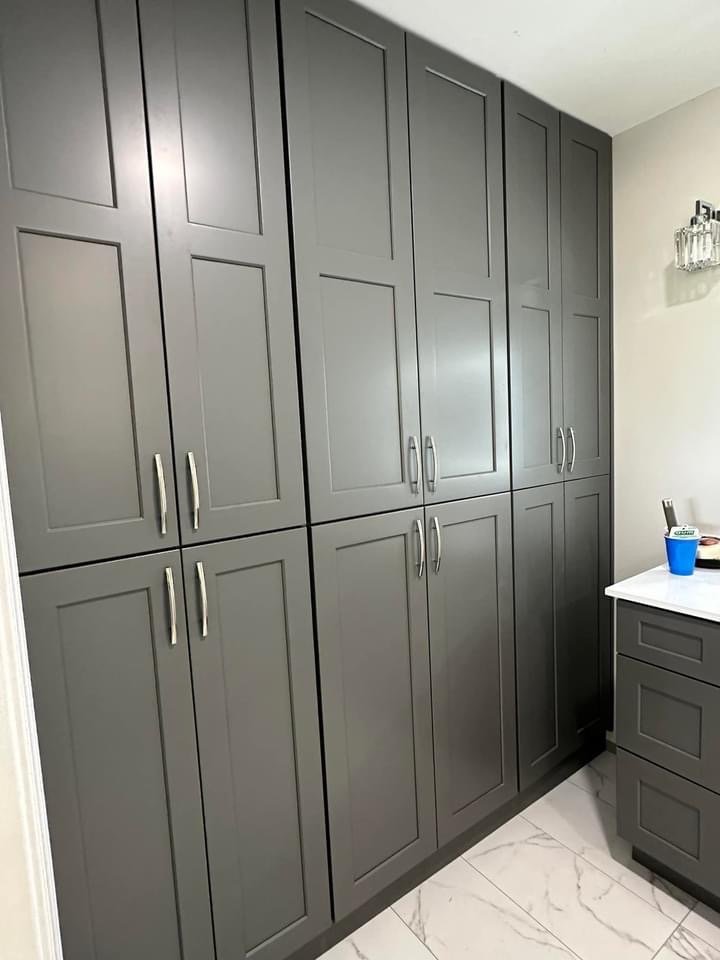 Floor-to-ceiling grey shaker pantry / laundry cabinets with brushed nickel pulls