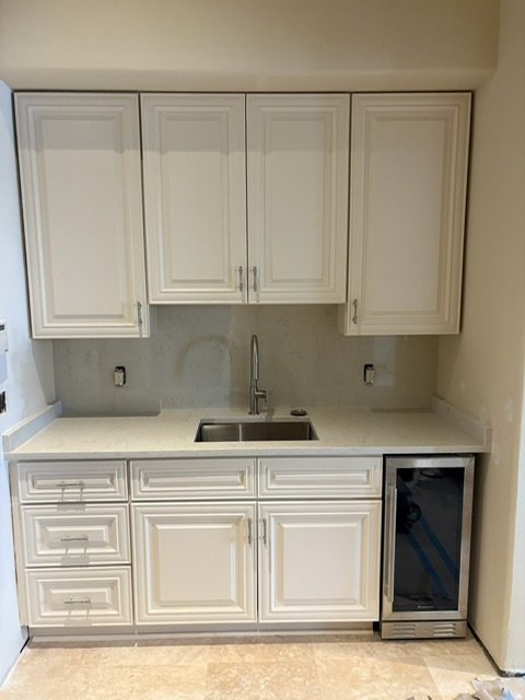 White wet bar / butler's pantry with raised-panel cabinets and beverage fridge