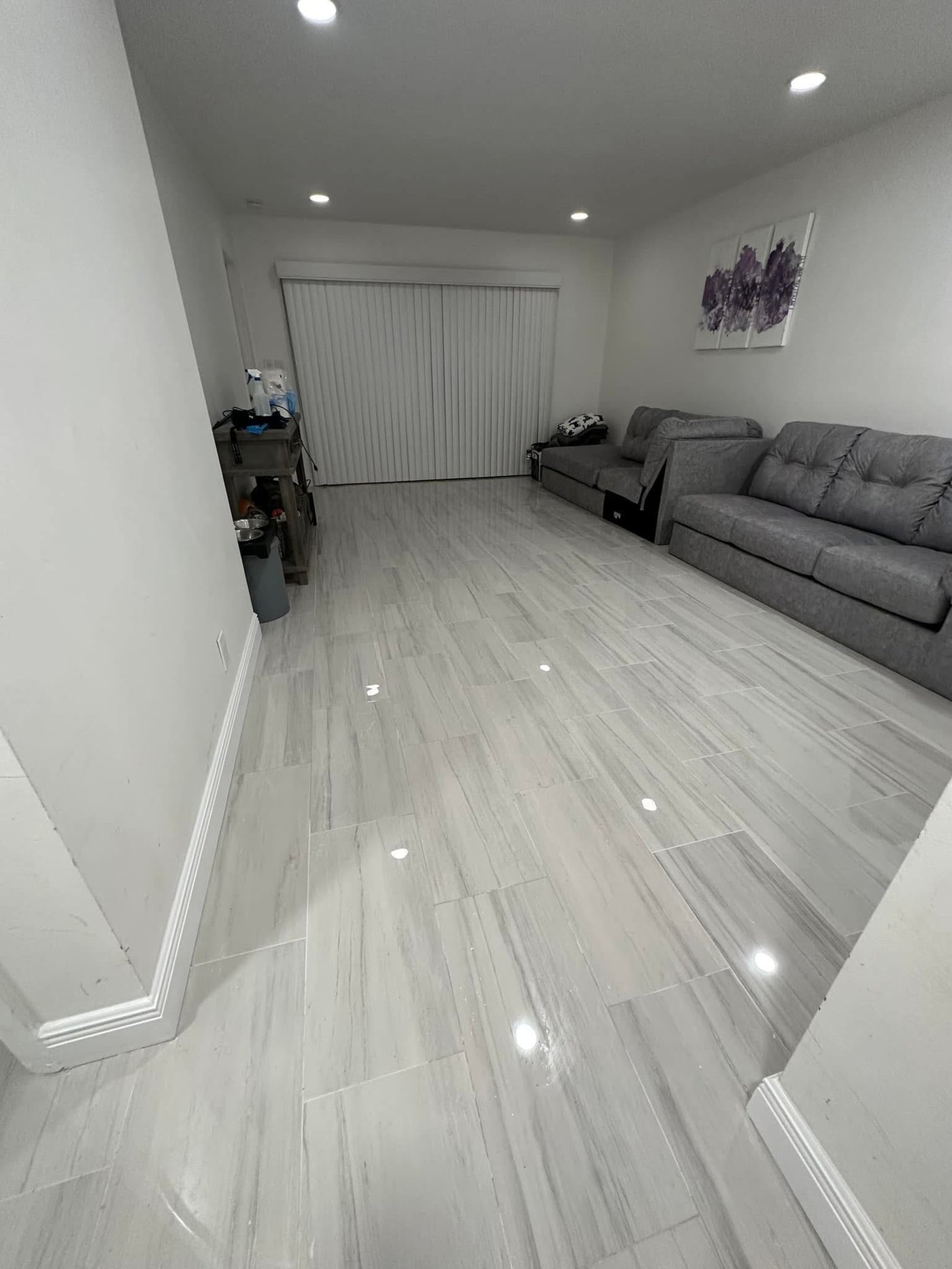 Large-format marble-look porcelain tile installation in an open-plan living room